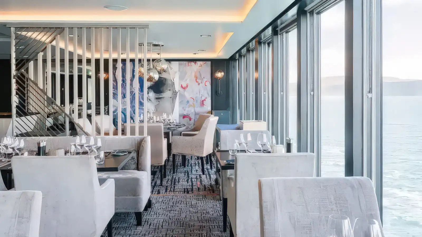 A window-lined dining room aboard a Hurtigruten expedition ship