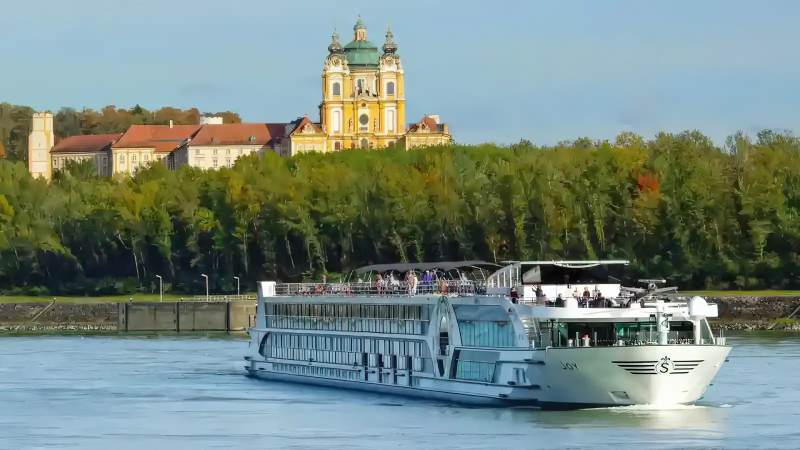 A Tauck riverboat cruising a European river past rolling countryside