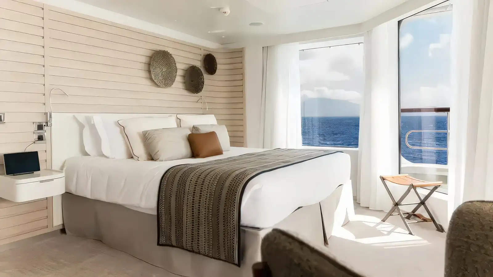 A refined stateroom with a private balcony aboard a Ponant ship
