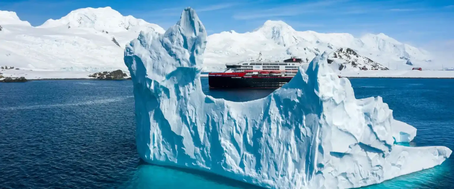 An expedition ship among Arctic ice and mountains