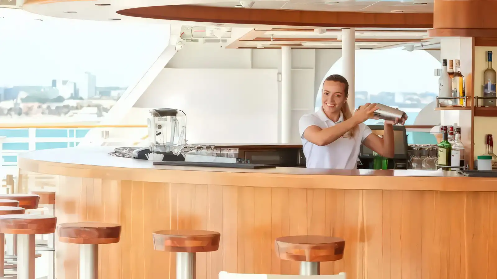 Guests enjoying an open-air lounge and bar aboard a Seabourn ship