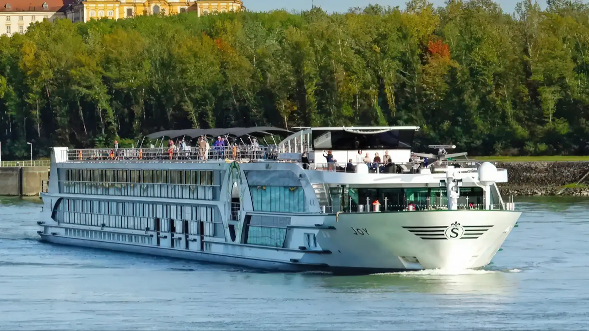 A river cruise ship on a European river at dusk